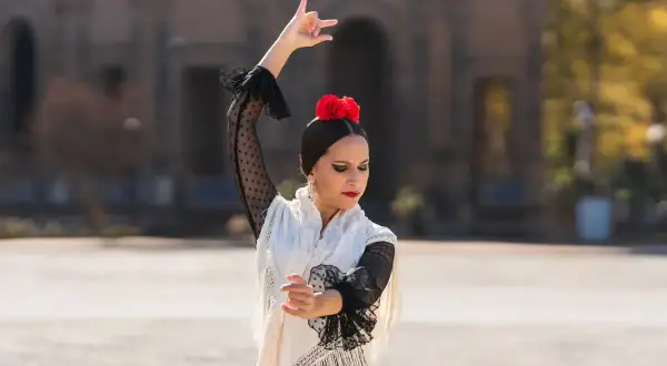 Bailaora de flamenco, con mantón y flor roja, capturando la esencia de la cultura del flamenco 3 eso.