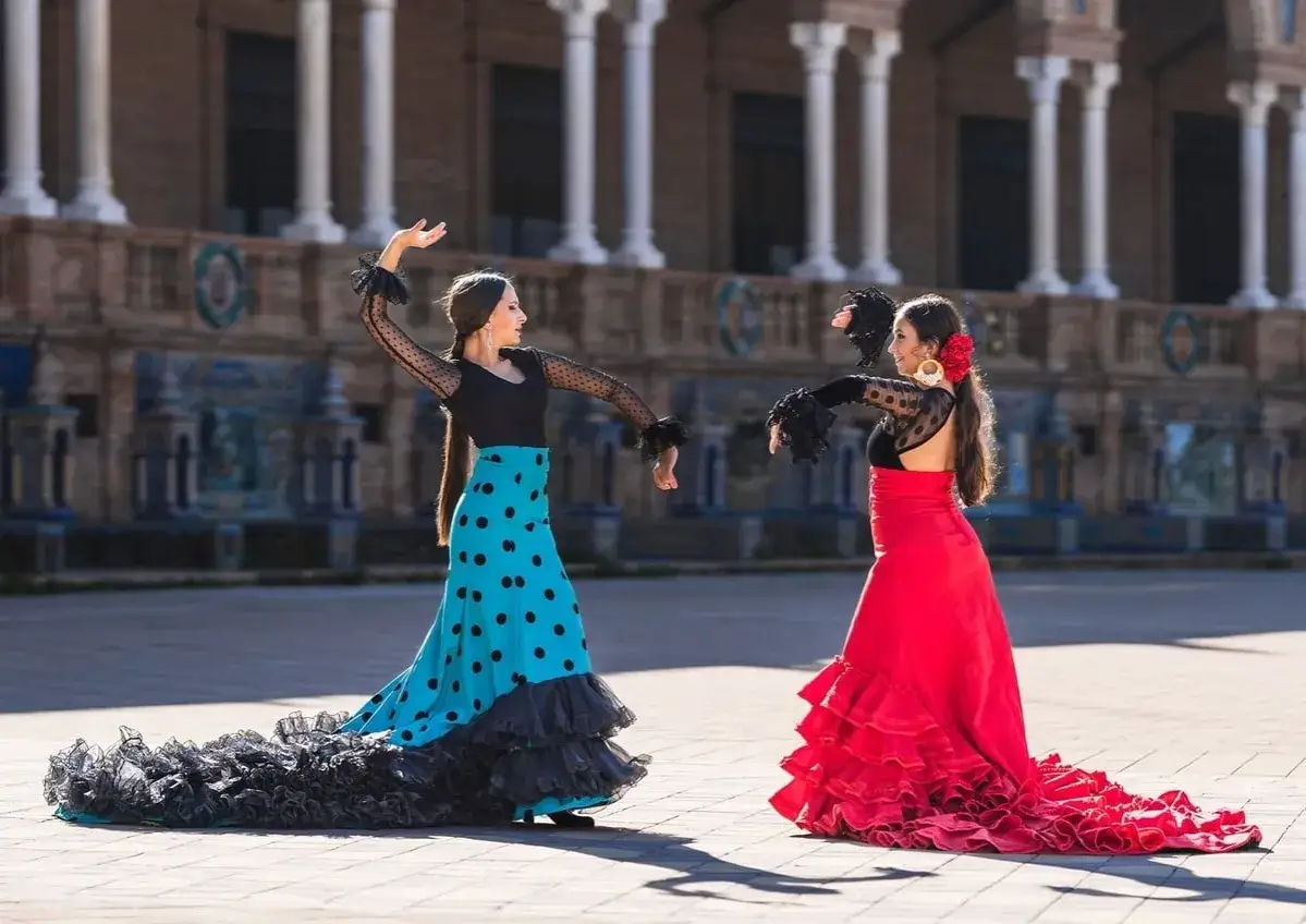 Dos mujeres bailan flamenco, el baile t&iacute;pico de Espa&ntilde;a, con trajes vibrantes.