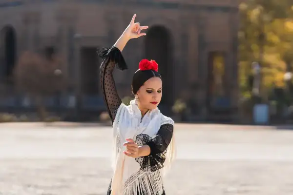 Bailaora de flamenco, con mantón y flor roja, capturando la esencia de la cultura del flamenco 3 eso.